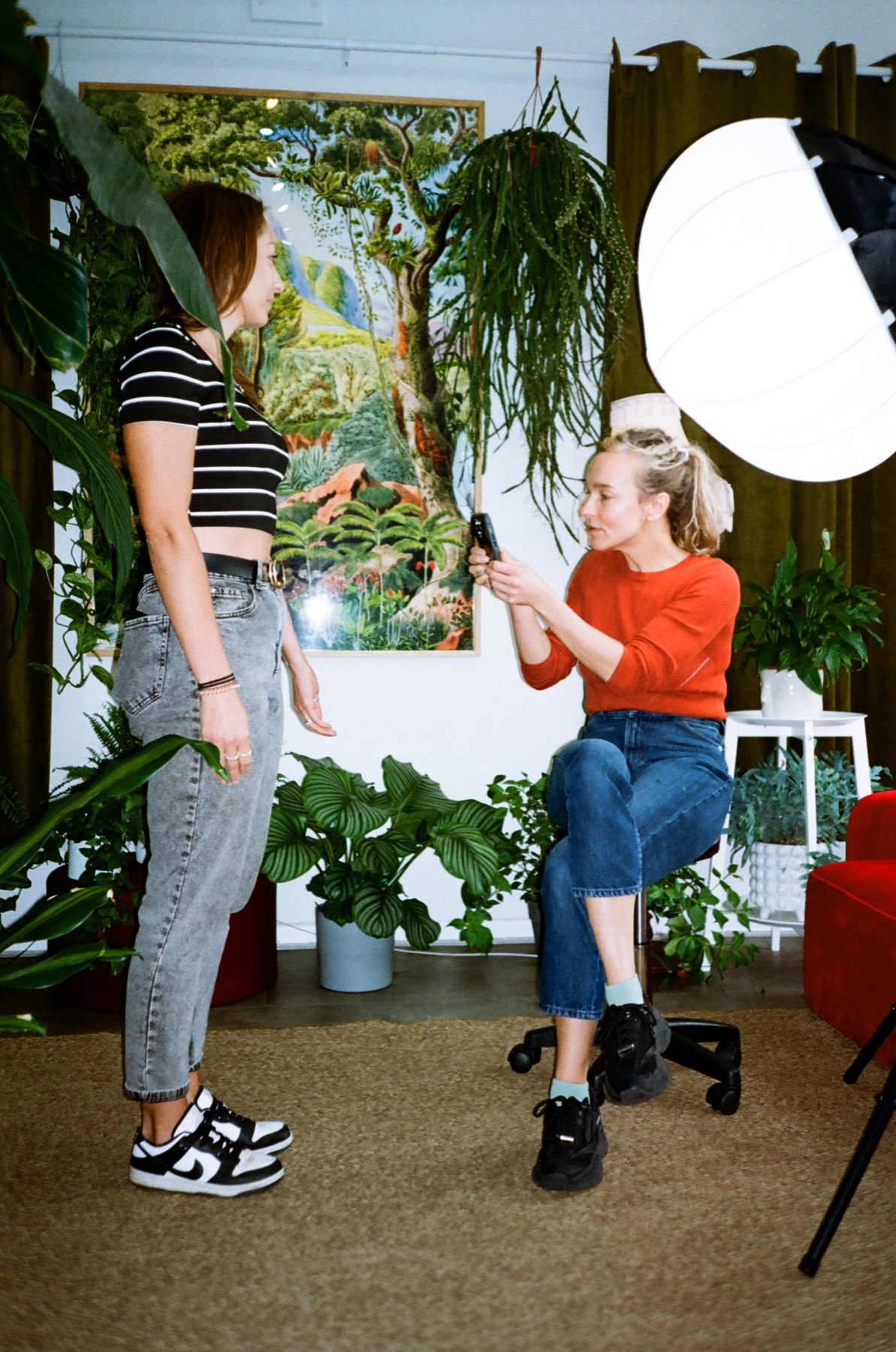 Gosia talking through a design with a client beside one of her botanical paintings, Bristol